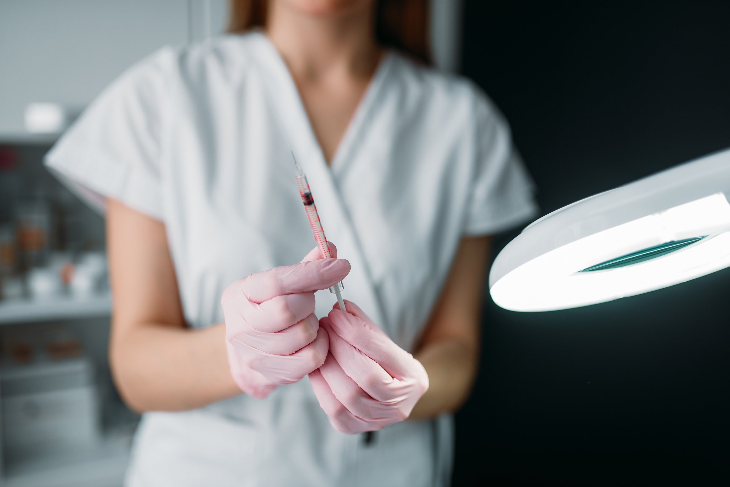 Beautician with syringe in hands, botox injection